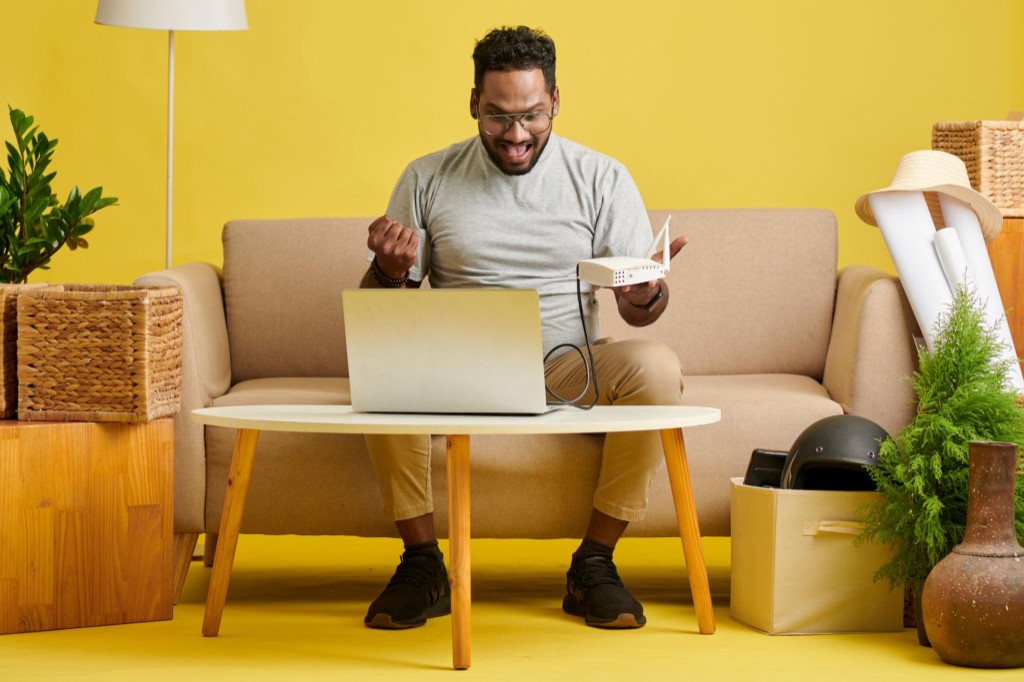 Indian family using high-speed WiFi at home — laptop and router, DishaFiber broadband Ahmedabad